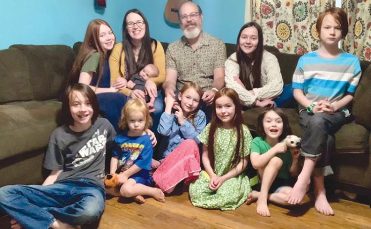 Randy and Mackenzie Chester are shown with their nine children Rosie, Paloma, Kells, Remy, Heidi, Azalea, Rune, Haven and Ezra.