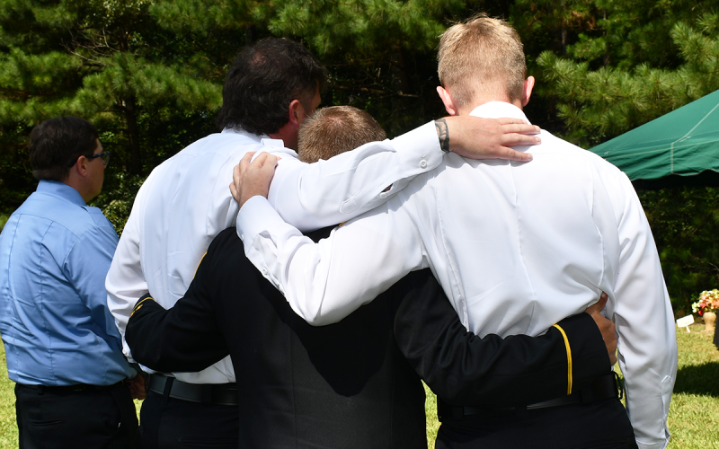Michael Hall, Cpt. Peyton Cagle, Lt. Kyle Dotson and Sam Osborne embrace during a moment of reflection. BRIAN WELLMEIER/Staff