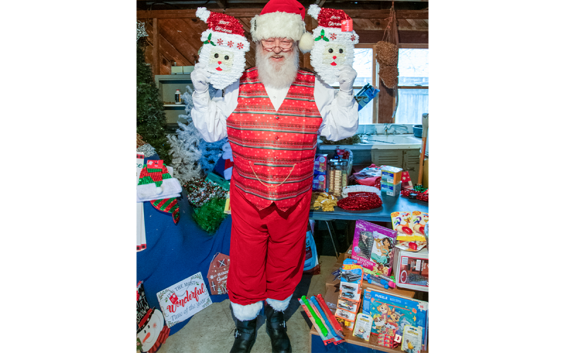 Which is the real Santa? Bob Williams, The Sophisticated Santa, holds two Santa head decorations. KIMBERLY BROWN/Staff