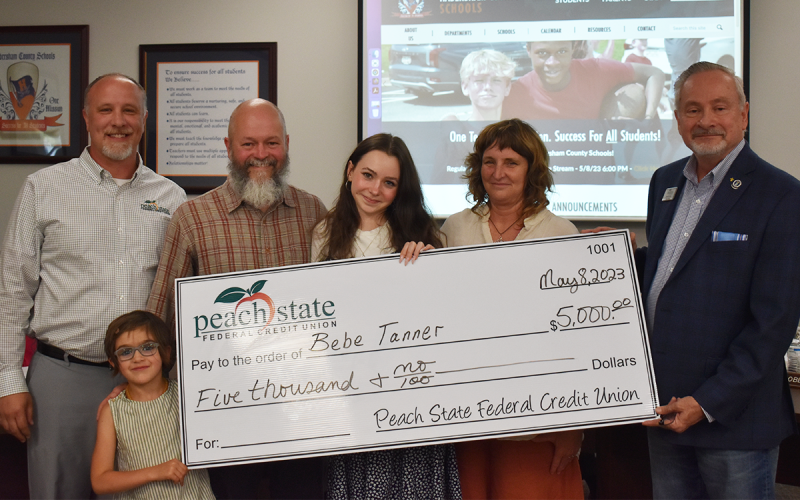 Bebe Tanner (middle) receives the Peach State Federal Credit Union Student Legacy Scholarship on Monday night. She is joined by (from left) Scott Roland from Peach State, sister Josie, father Ben, mother Kristin Costley-Tanner and Chief of Staff at Peach State John Fair.  EMMA MARTI/Staff 
