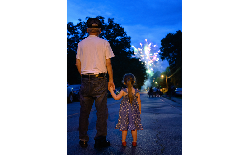 A grandfather and his granddaughter hold hands as they admire the fireworks lighting up the night sky above Baldwin on Airport Road. ZACH TAYLOR/Special
