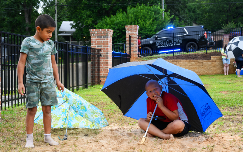 As he waits for the  9 p.m. fireworks show, Charlie Garcia (right) sits under an umbrella and watches a YouTube video. ZACH TAYLOR/Special
