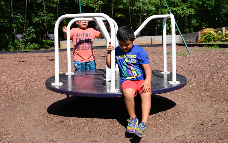 After sliding on the playground equipment, Gorgie (left) and Elijah (right) play on the merry-go-round in Cornelia City Park on Wednesday. ZACH TAYLOR/Special