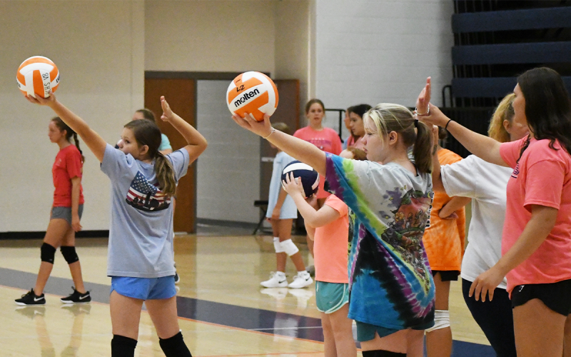 From left, Demilah Miller and Amelia Baker work on their serves during the final day of Habersham’s Lady Raider Volleyball Camp. LANG STOREY/Staff