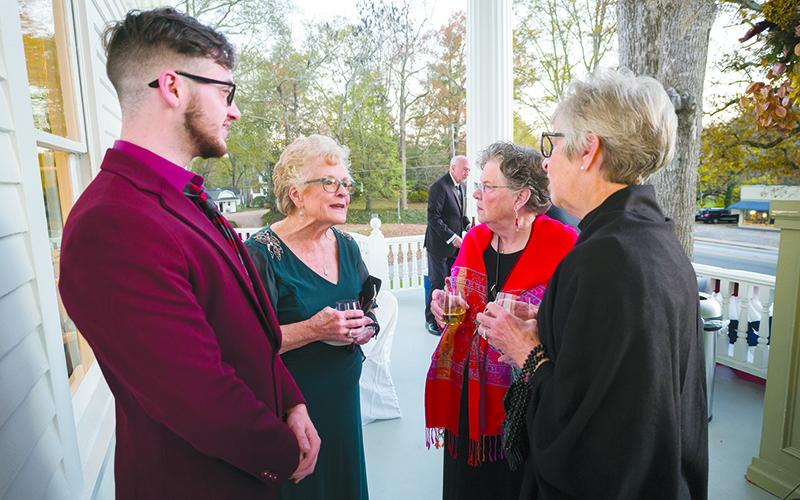 From left,  CJ Ramsaur, Lynn Ramsaur, Barbara Johns and Tina Evans socialize on the front porch of  the newly renovated Charm House. ZACH TAYLOR/Special