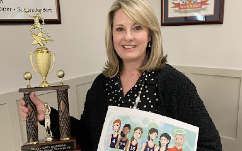 Kristie Dover holds a basketball themed book dedicated to her late husband and Raiders Coach Shane Dover. SUBMITTED