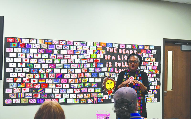 Audrey Davenport speaks in front of artwork by local school children to draw inspiration for the upcoming Tim Loves Tink mural. JULIANNE AKERS/Staff