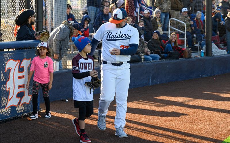 Raiders coach Chris Akridge hands a ball to Joaquim Mayfield to throw the ceremonial first pitch before the Stephens County matchup. ZACH TAYLOR/Special