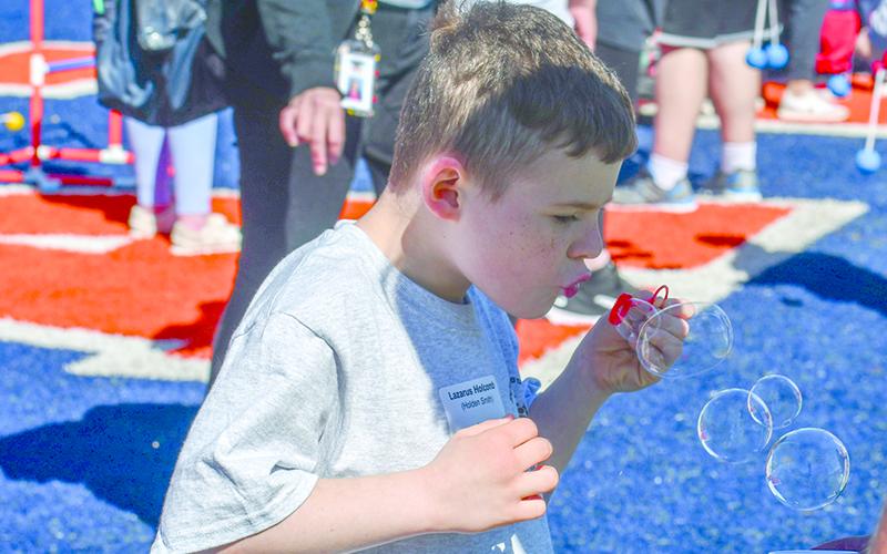Lazarus Holcomb, second grade, blows bubbles in between events. JULIANNE AKERS/Staff