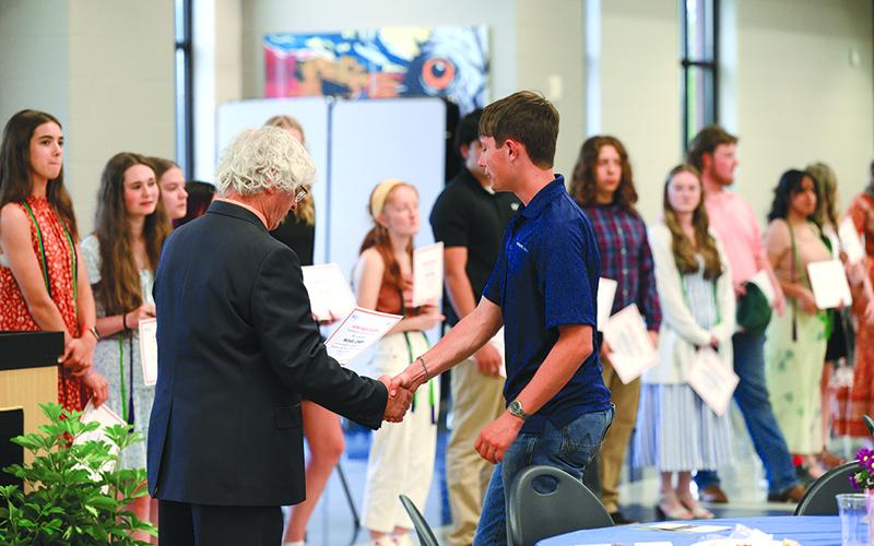 Habersham Soccer star MJ Lowery shakes hands with Brooks as he receives his Raider Work Ready Certificate. ZACH TAYLOR/Special