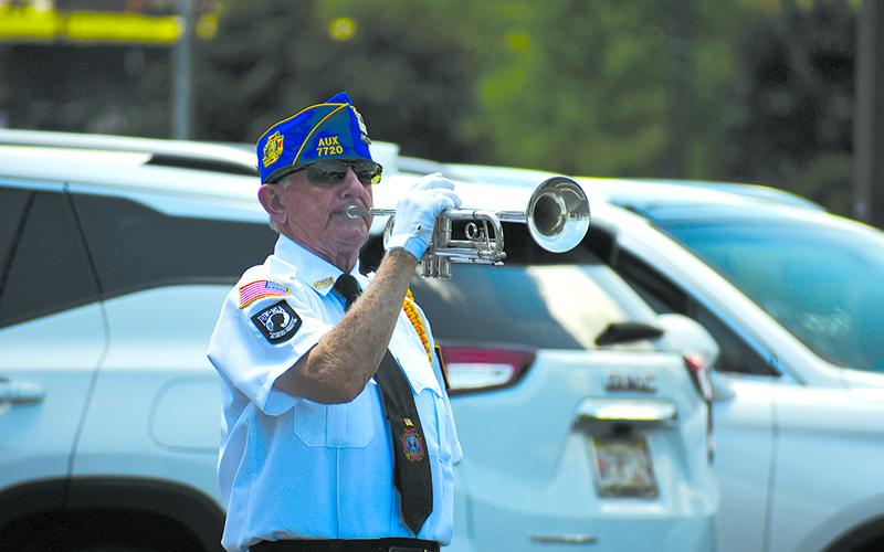 Danny Stephens plays the bugle at Cornelia following a volley by the Honor Guard. JULIANNE AKERS/Staff