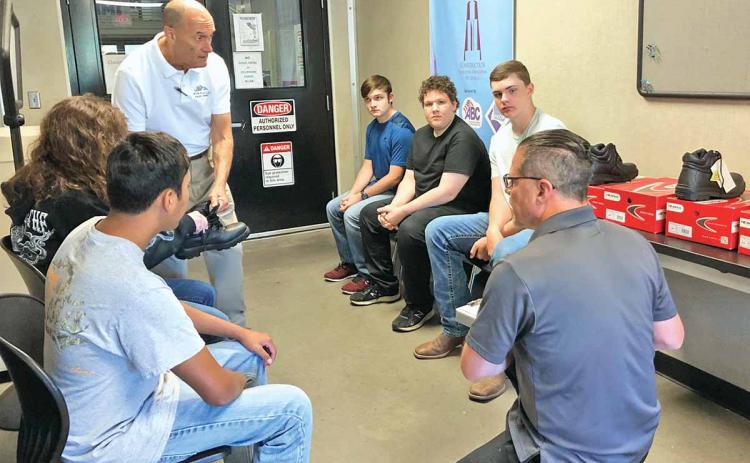 Habersham Central High School students in the dual-degree welding program at North Georgia Technical College were fitted Thursday morning for their safety boots. Students shown sitting in a circle, left to right, are 10th-grader Gabe Blackburn, 12th-grader Katie McCoy, 11th-grader Joshua Brock, 11th-grader Adrian Frankum and 10th-grader Drew Maneg. (Photo/CHAMIAN CRUZ)