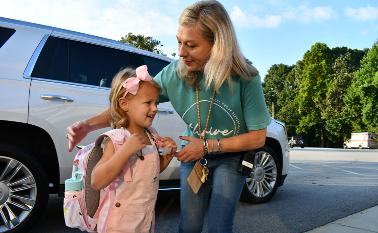 Hallie Hatchett is greeted by Assistant Principal Jennifer Porter at Hazel Grove Elementary on the first day of school. BRIAN WELLMEIER/Staff