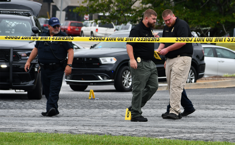 Cornelia Police officers assess the crime scene in the parking lot of the United Community Bank on U.S. 441. MATTHEW OSBORNE/Staff