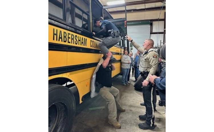 Lt. Matt Wurtz helps Deputy  Victoria Hopper through the emergency window of a school bus while Lt. Travis Jarrell assists with the training exercise in January. SROs and other educators will undergo more safety training in June. FILE