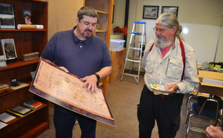 Demorest Councilman Shawn Allen shows a land plat from the 1890s to Dr. Rick Gadbois at Monday’s open house at Demorest City Hall. MATTHEW OSBORNE/Staff