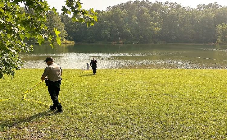 Personnel from the Georgia Department of Natural Resources Law Enforcement Division and Habersham County Emergency Services remove the tape the yellow tape that had marked the operational area during Saturday afternoon’s incident in the swimming area at Lake Russell Beach near Mt. Airy. HABERSHAM COUNTY/Submitted