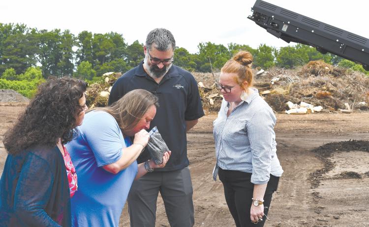 Baldwin Councilwoman Stephanie Almagno, Mayor Alice Venter, ReveSolutions Owner Carlos Talbott and Baldwin Chief Administrative Officer Emily Woodmaster take a moment to smell the compost end-product from the Athens-Clarke County Solid Waste Department. JOHN DILLS/Staff