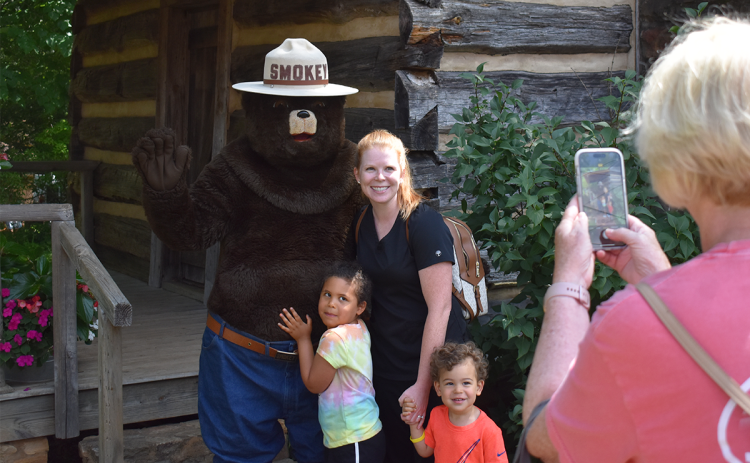 From left, Lorelai, Ashley and Major Davis pose with Smokey Bear while Linnely Dockery, also known as Yaya, takes a photo. EMMA MARTI/Staff