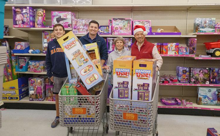 Carson Crane, Habersham Kiwanis Club President Brad Crane,  Habersham Kiwanis Club Secretary Nellie Snyder and Habersham Kiwanis Club Honorary Member Clay Christie stand behind full shopping carts for a photo. ZACH TAYLOR/Special