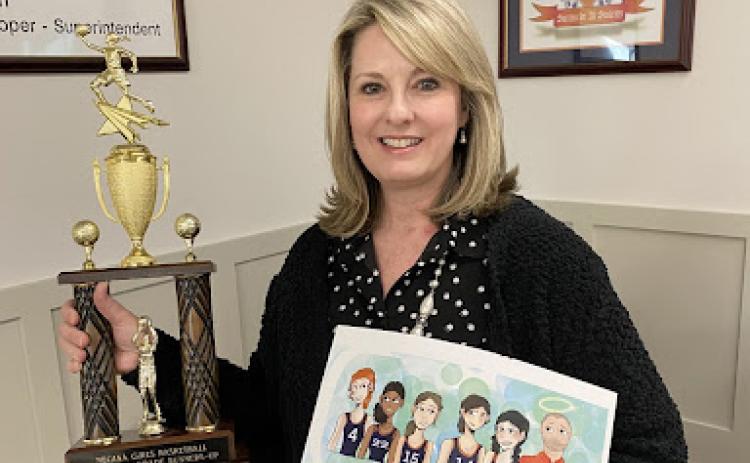 Kristie Dover holds a basketball themed book dedicated to her late husband and Raiders Coach Shane Dover. SUBMITTED