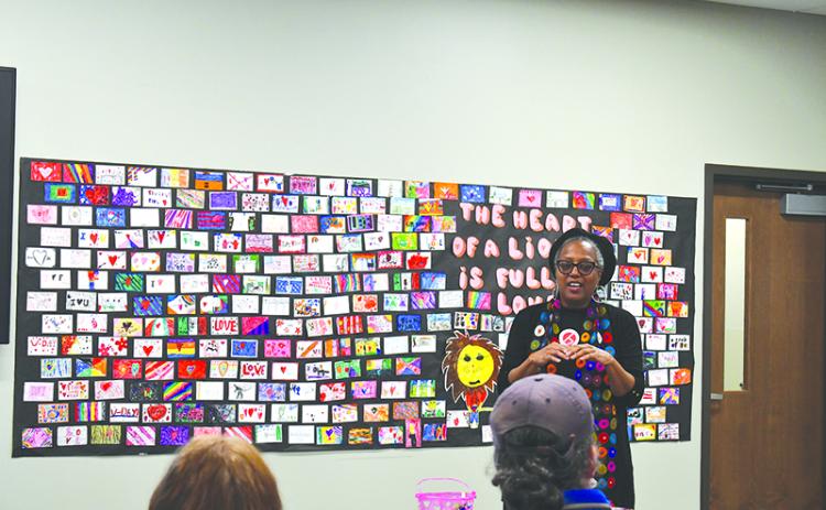 Audrey Davenport speaks in front of artwork by local school children to draw inspiration for the upcoming Tim Loves Tink mural. JULIANNE AKERS/Staff