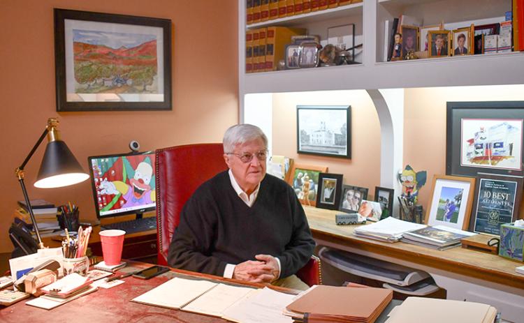 Cathey sits at his desk in his downtown Cornelia office. A drawing of Rabun County Courthouse is mounted on the wall behind him along with family photos and his beloved fictional character, Krusty the Clown. JULIANNE AKERS/Staff