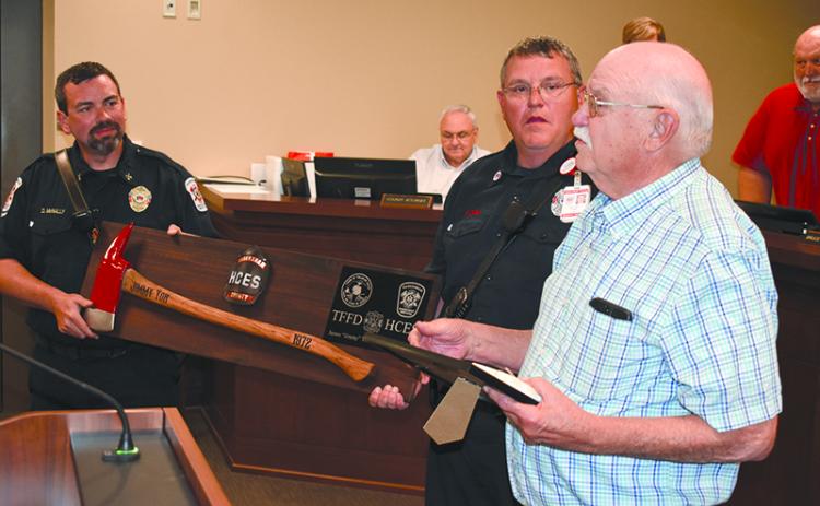 Habersham County Emergency Services Battalion Chief Dwight McNally (left) and firefighter Kyle Cash help present Jimmy Yon with a commemorative fireman’s axe at the April meeting of the Habersham County Board of Commissioners. MATTHEW OSBORNE/Staff