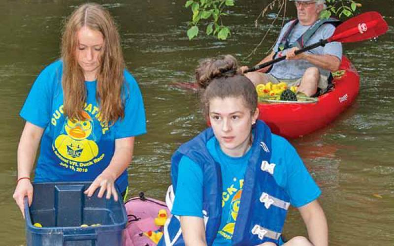 Emily Wonders, left, helps Elizabeth Hughes offload yellow rubber ducks.