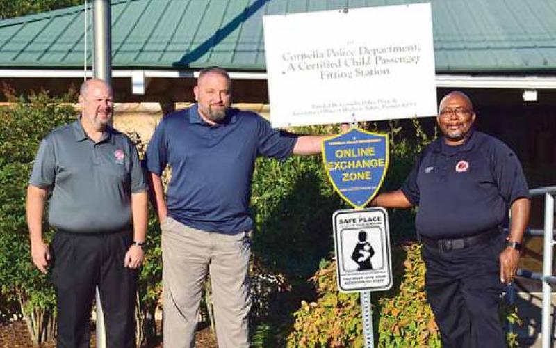 Shown with one of the new "safe haven" signs, located at the Cornelia Police Department, is, from left, City Manager Donald Anderson, Police Chief Chad Smith and Fire Chief Billy Jenkins Jr.