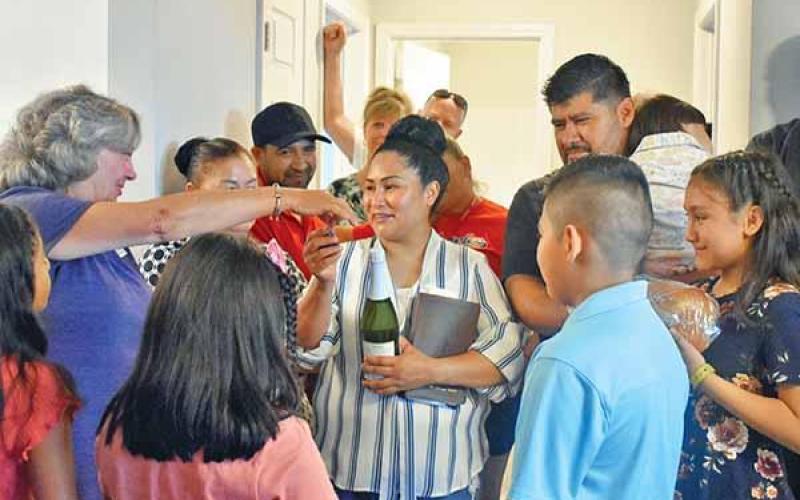 Shown is Habitat for Humanity of Northeast Georgia Executive Director Nanette Baughman reaching over to hug Deyci Rodriguez, surrounded by the rest of the Rodriguez family, who on Sunday were dedicated Habitat’s 71st house. (CHAMIAN CRUZ/Staff)