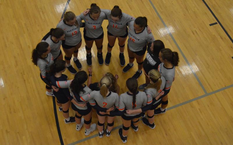 The HCHS Volleyball team huddles during a timeout Thursday.