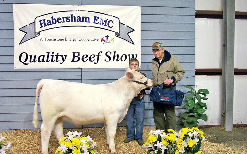 Barrett and one of his three grandchildren smile for a picture after the Habersham Electric Membership Corp. Quality Beef Show. Barrett was inducted into the 2019 Habersham County Farm Bureau Agriculture Hall of Fame Friday for his contributions to the agricultural community.