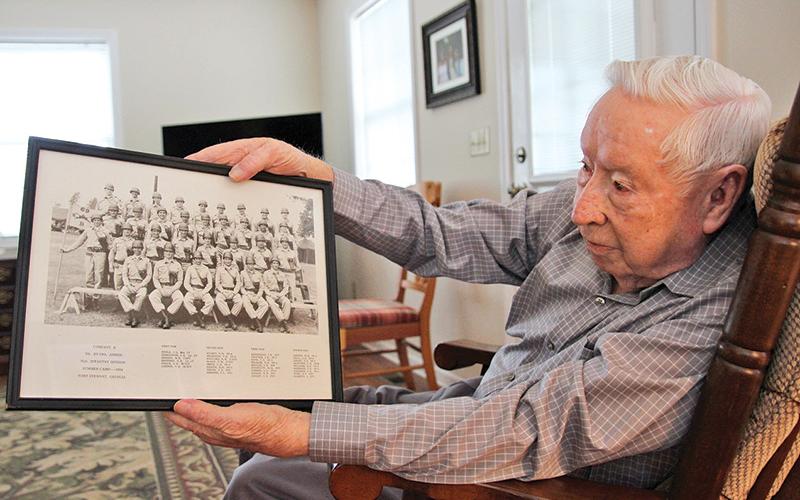 Donald Tench shows a photo from his Army days. Tench, 90, served 38 years in the Army and reserves. He continues to participate in military funerals which he has done for over 60 years.