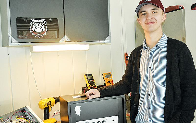 Maison Cloautre’s hobby of building boutique guitar amplifiers led him to have one of his own included at Capricorn Studios for musicians to use alongside those made by Fender and other big names. Clouatre poses for a photo while displaying the inside of his very first boutique guitar amplifier, which he continues to work on today.