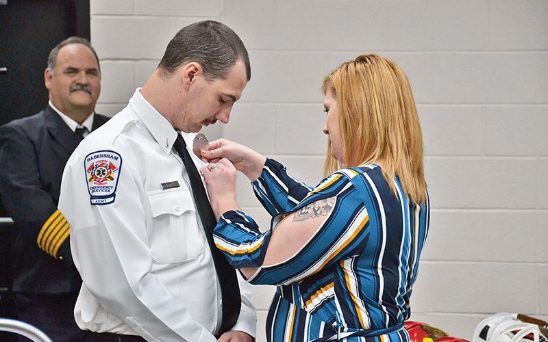 Lt. Joseph Deal has his EMS badge pinned on by fiancee Monica Dean during a ceremony Friday in Clarkesville.