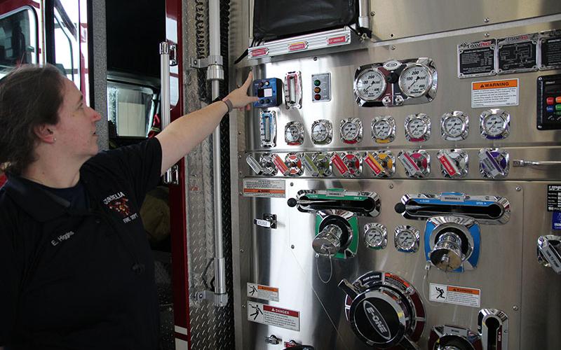 Cornelia firefighter Erin Higgins points out the foam gauge on the engine. Several local departments already use environmentally friendly foam.