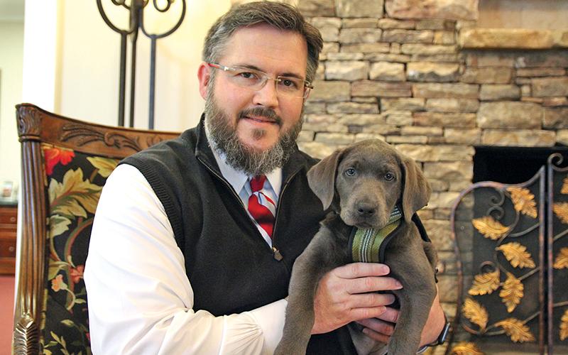 Hillside Memorial Chapel and Gardens owner Brent Tolbert hold Shiloh, the newest addition to their workforce.