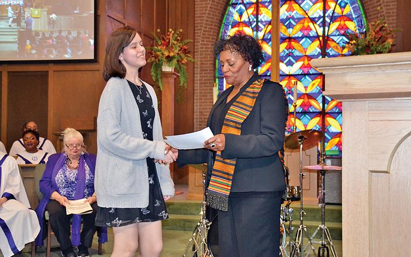 Dr. Vanessa Burns congratulates Brianne LaPerriere (left) on winning second place in the Alliance’s art contest. First-place winner Molly Butler was unable to attend the concert Sunday.
