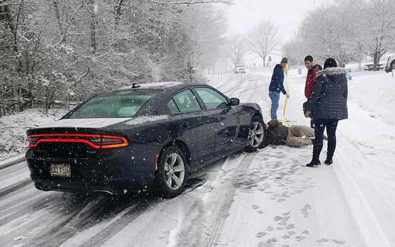 Motorists try to help each other during the icy conditions Saturday on Level Grove Road. Snow fell quickly around lunchtime while many drivers were out doing their weekend errands, causing many minor accidents.