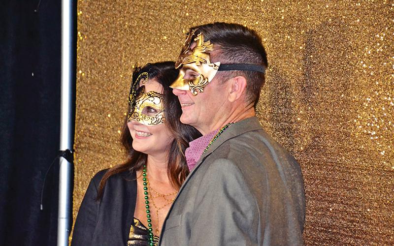 Some folks took advantage of the red carpet photo booth at the Mardi Gras event.