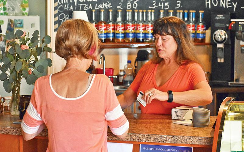 Angie Guthrie, owner of Java Joe’s Coffee Shop in Clarkesville, sells a gift card to Sheila Humphrey on Saturday. Photo by CODY ROGERS/Staff