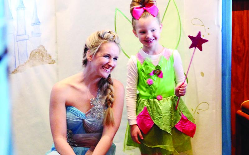 Camryn Ker, 5, shown right gets a photo with Mary Beth Simmons. Several families came to the breakfast Saturday morning.