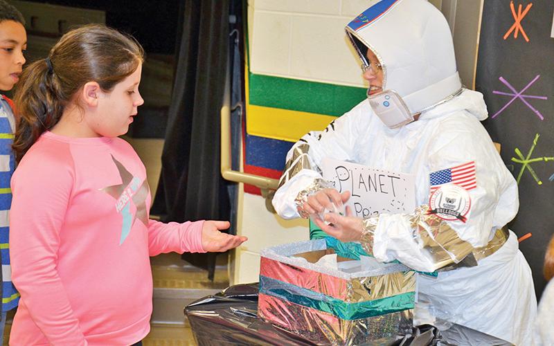 Level Grove student Alyssa Chitwood gets a prize from “astronaut” Michele Shockley.