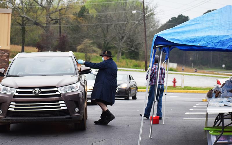 The Habersham Seventh Day Adventist Church gave away bags full of medical masks, gloves, a bottle of hand sanitizer, a digital thermometer and books to anyone that drove through the Quality Foods parking lot Sunday at 9 a.m. Shown from left are Dortch Williams and Jorge Guillen. Not pictures are Rodney Sykes, Pat Williams and Rodney Williams, who also helped with the giveaway. Photo by CODY ROGERS/Staff