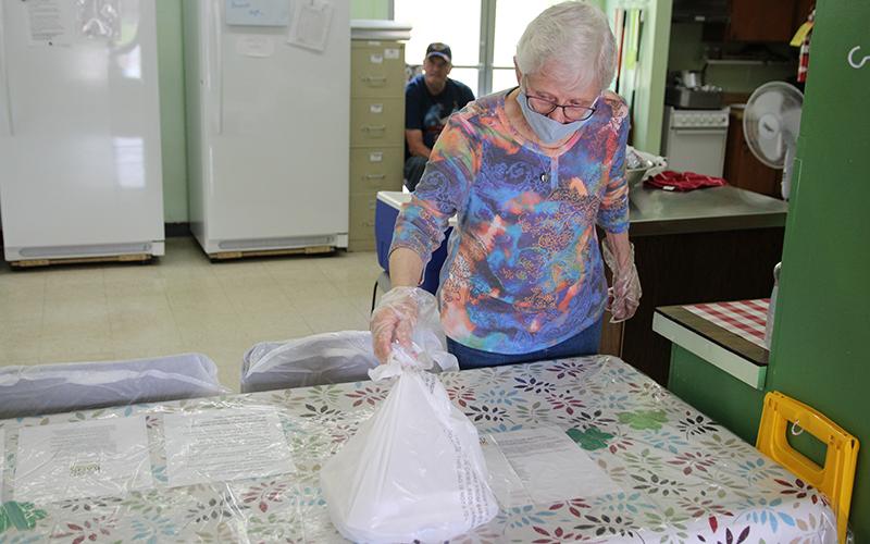 Habersham Soup Kitchen volunteer Geriann Jones prepares a plate to hand out during their lunch take out hours. The soup kitchen has distributed more than 600 meals since March 19. Photo by ERIC PEREIRA