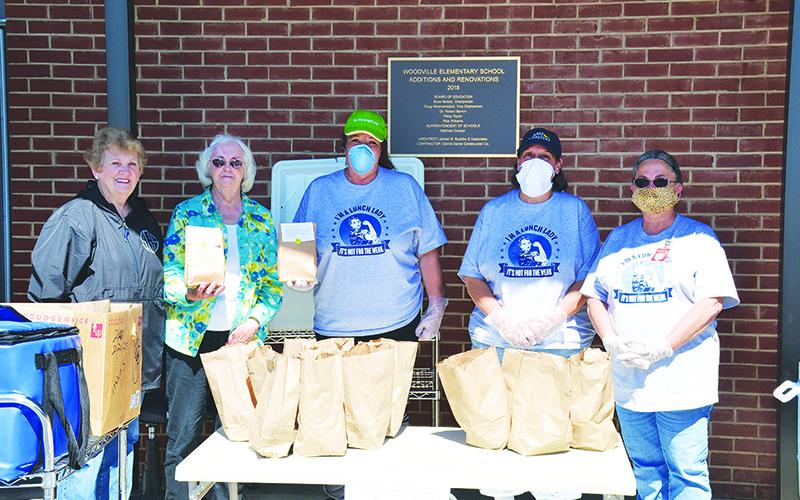 Shirley Grant, president of Habersham Retired Educators Association, and fellow member Beatrice York present care packages to Liz Martin, manager of Woodville cafeteria, Mary Beth Justice of the Ninth Grade Academy and Jackie Cane of Woodville Elementary on Friday morning.