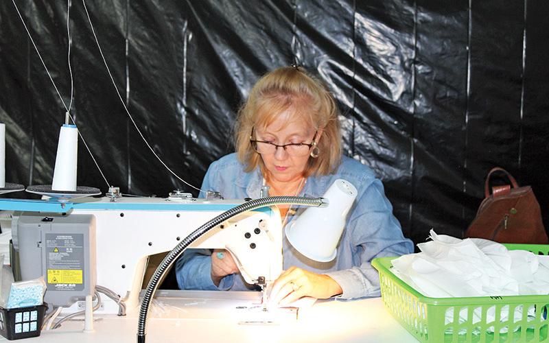 Cathy LaPrade works on a protective mask at My Pool Pal in Alto.