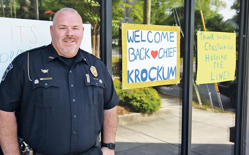 Demorest Police Chief Robin Krockum stands outside his department with signs showing community support.