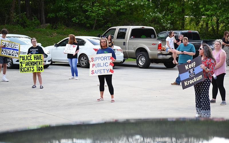 Jennifer Austin, Heather Dotson and Saylor Krockum hold up signs of protest at the Demorest gathering April 28.